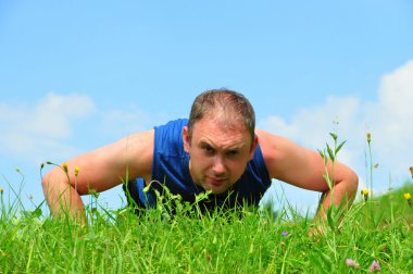 Fitness egzersizleri çim gökyüzü yapan erkek