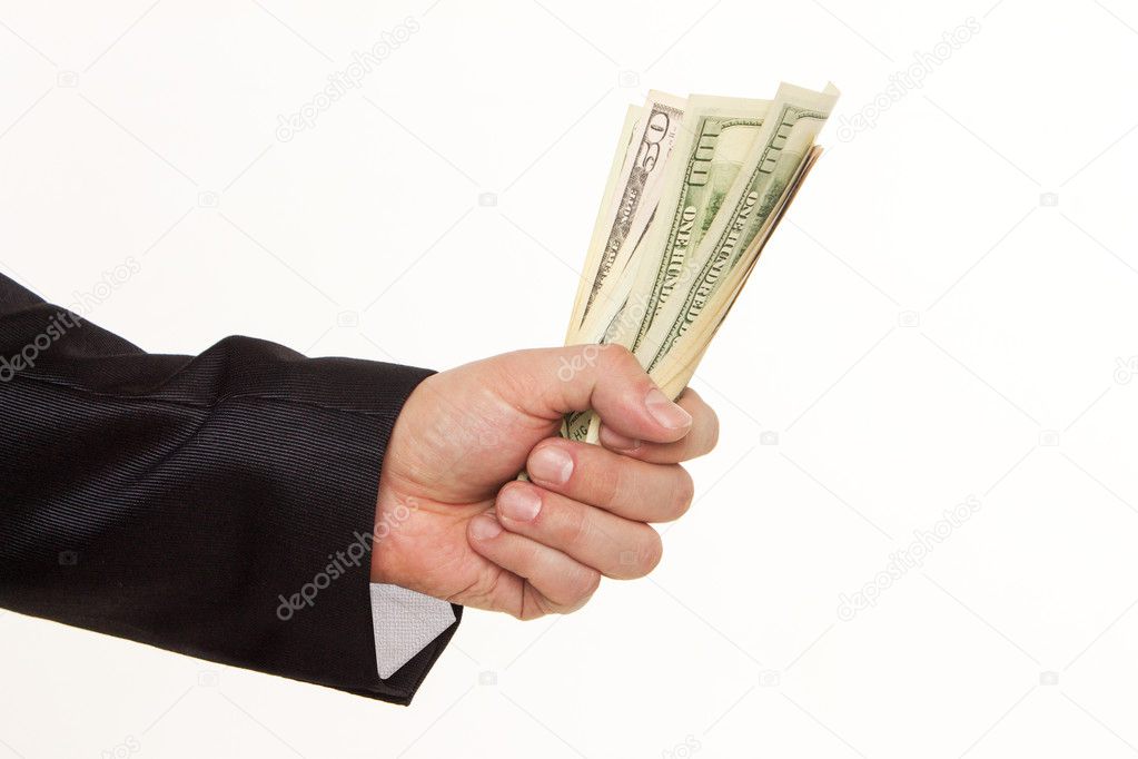 A man's hand holding a handful of dollars.