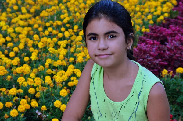 Retrato de uma menina bonita em um fundo de flores — Fotografia de Stock