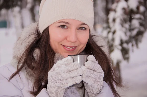 Hermosa chica bebiendo de un termo invierno — Foto de Stock