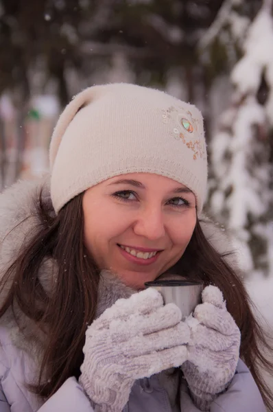 Hermosa chica bebiendo de un termo invierno — Foto de Stock