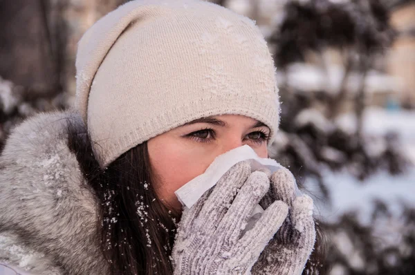 Tyttö nenäliina on flunssa ja käynnissä nenä talvi — kuvapankkivalokuva