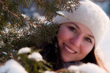 Mutlu kız kış ağaçların arkasından gözetleme