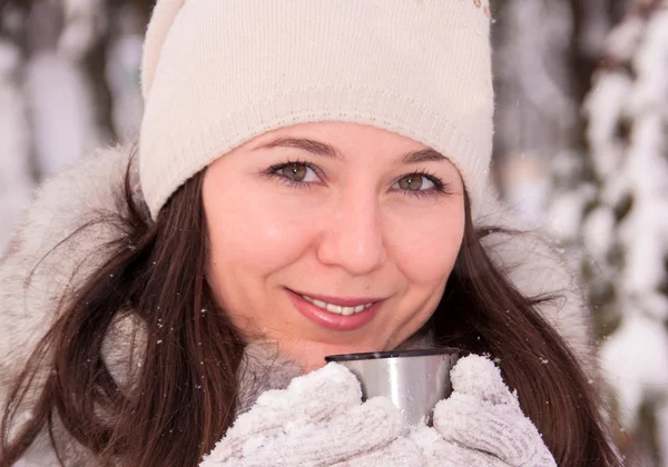Hermosa chica bebiendo de un termo invierno — Foto de Stock