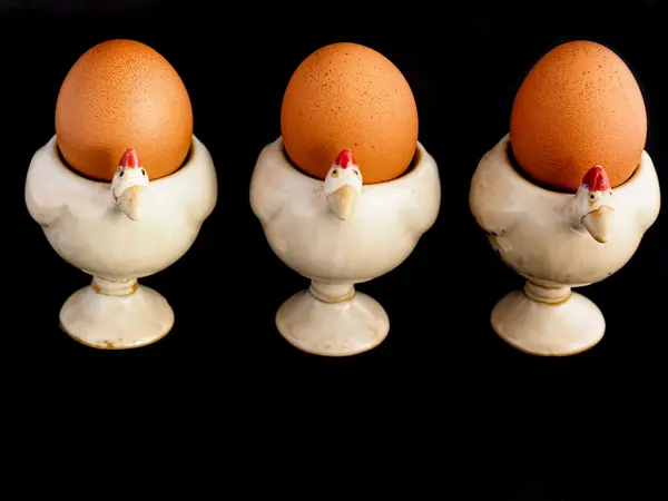 Три яйца на яичной чашке — стоковое фото