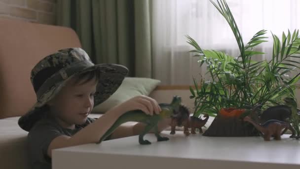 Boy Plays Dinosaur Figurines Table Little Explorer Hat Handheld Close — Stock Video