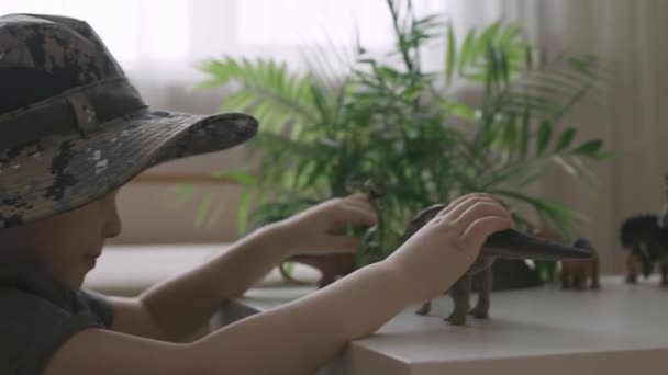 Bir Çocuk Masada Dinozor Heykelcikleriyle Oynuyor Şapkalı Küçük Kaşif Kamerasıyla — Stok video