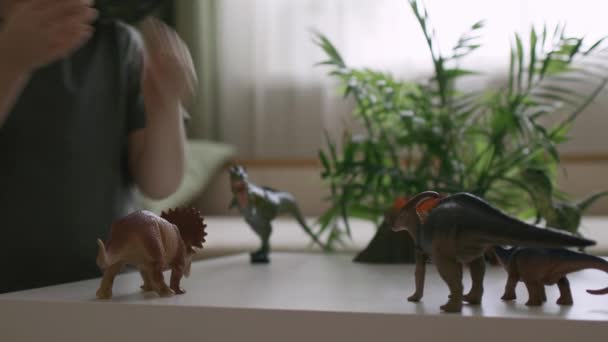Chłopiec Bawi Się Figurkami Dinozaurów Stole Mały Odkrywca Kapeluszu Podręczne — Wideo stockowe