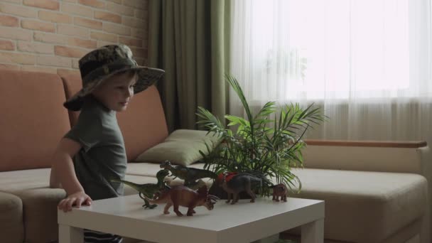 Chłopiec Bawi Się Figurkami Dinozaurów Stole Mały Odkrywca Kapeluszu Średni — Wideo stockowe