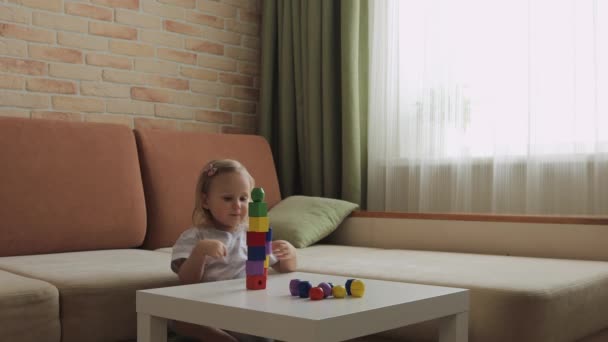 小女孩在桌子上玩木制几何图形 对彩虹立方体进行分类中枪 — 图库视频影像