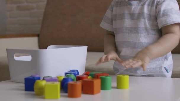 小女孩在桌子上玩木偶戏 把立方体放进盒子里手持式近距离射击 — 图库视频影像