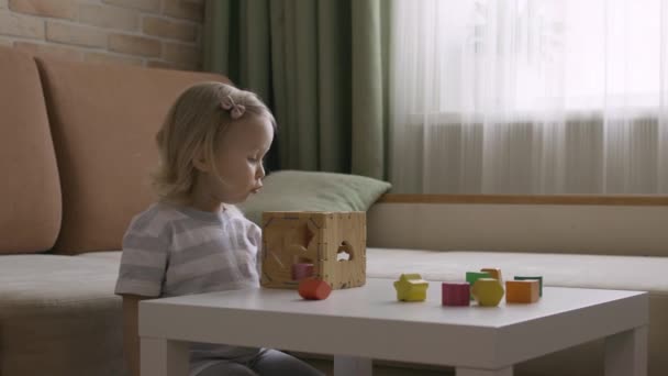 Masada Geometrik Figürlerle Tahta Kutu Oynayan Küçük Bir Kız Gökkuşağı — Stok video