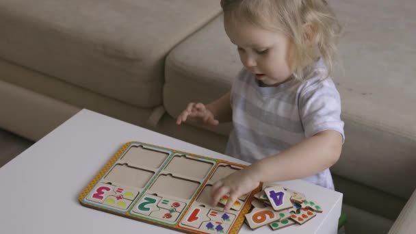 Little Girl Playing Puzzel Numbers Table Figures Handheld Close Shot — Stock Video