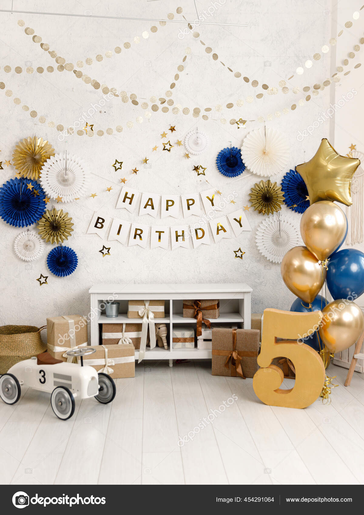 Birthday decorations with balloons, gifts, toys, garlands and candy for  yearling, little baby party, celebration on a white wall background. Black  and gold Decor elements. Stock Photo