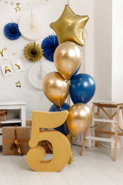 Doğum günü süslemeleri - hediyeler, oyuncaklar, balonlar, çelenkler ve beyaz arka planda küçük bir bebek partisi için numara.