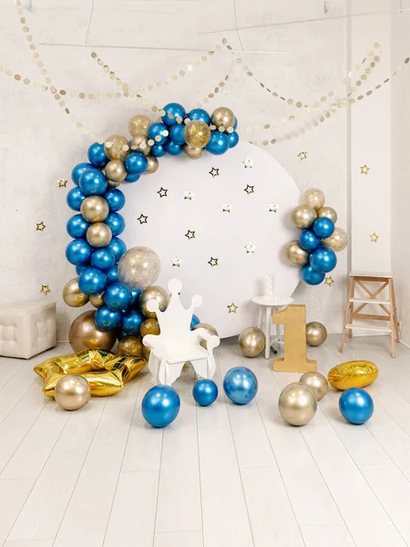 Birthday decorations - gifts, toys, balloons, garland and number for little baby party event on a white wall background.