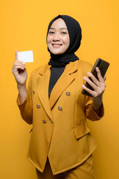 smiling Muslim women holding smartphones and business cards
