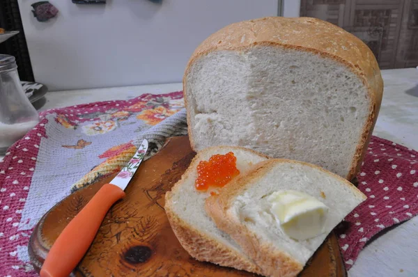 Pan blanco en una tabla con caviar rojo — Foto de Stock