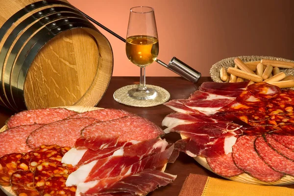 带有典型的西班牙食物的静止生活 来自赫雷斯的火腿 Chorizo Salchichon和Amontillado葡萄酒 免版税图库图片