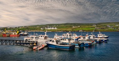 Kerry 'nin İrlandalı köyü Portmagee' deki limanın panoramik manzarası, ön planda birkaç balıkçı teknesi ile.