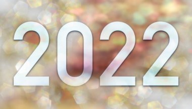 Yeni yıl 2022, arka planda altın ve pembe tonlardaki odaksız parlayan ışıkların görüntüsü var..