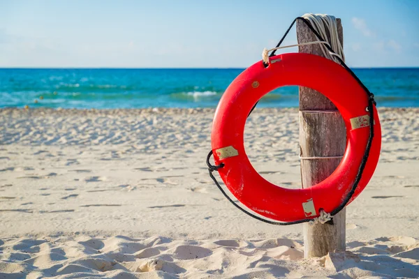 Life buoy on a pole on a beach in Mexico — Stock Photo, Image