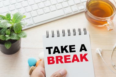 A Break mesaj kitap ve bir fincan sıcak çay, klavyeyle tutan adam masada acıbadem kurabiyesi. Reklamınız için bağlanabilir.