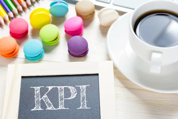 Concetto messaggio KPI su tavole di legno.Macaron e caffè in vetro sul tavolo. tono vintage . — Foto Stock