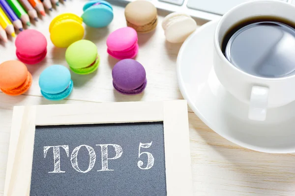 Konzept Top 5 Botschaft auf Holzbrettern. Makronen und Glaskaffee auf dem Tisch. Vintage-Ton. — Stockfoto