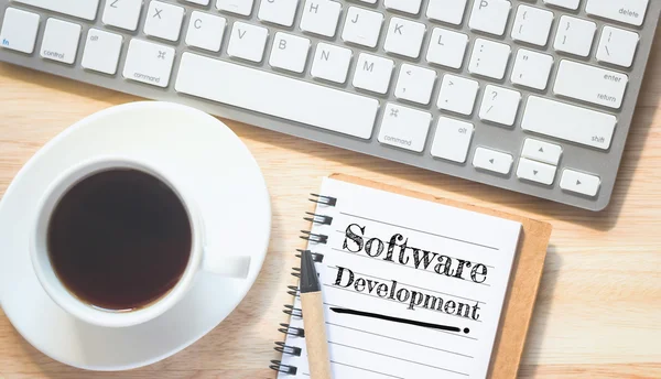 Concepto Software Mensaje de desarrollo en libro. Un lápiz y una mesa de café de vidrio. . —  Fotos de Stock