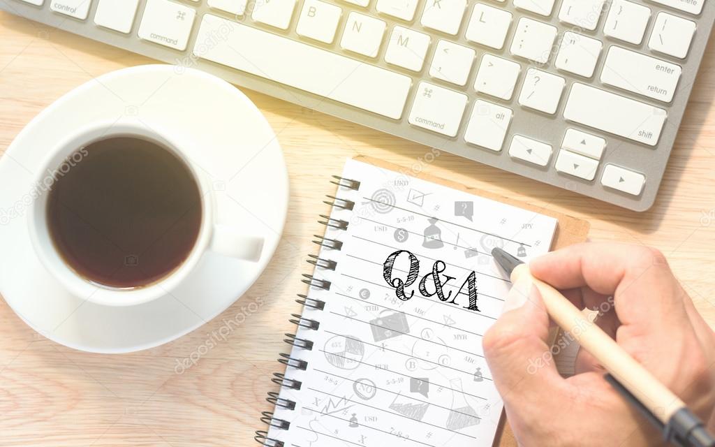 Hand writing on book message Q&A. A keyboard and a glass coffee table.Vintage tone.