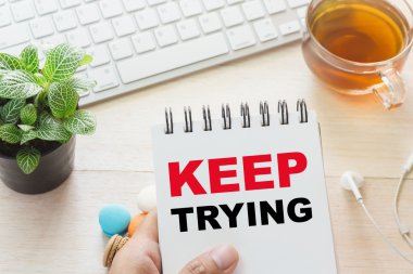 Denemeye devam et mesaj kitap ve bir fincan sıcak çay, klavyeyle tutan adam masada acıbadem kurabiyesi. Reklamınız için bağlanabilir.