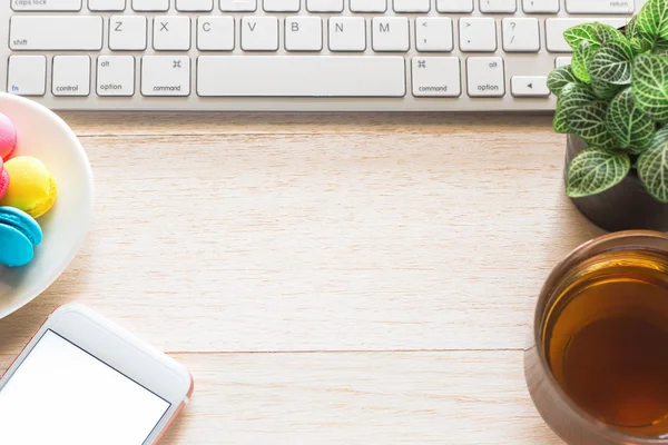 Espace de travail de bureau avec clavier portable café de tasse et smartphone sur table en bois . — Photo