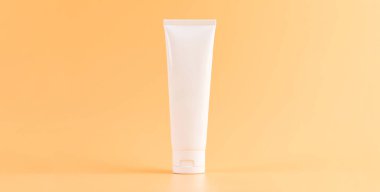 İlaç şişesi yerleştirilmiş, turuncu arka plan için boş etiket paketi. Doğal güzellik ürünleri kavramı.