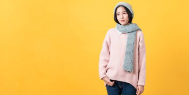 Açık renkli tişörtlü neşeli Asyalı kadının stüdyo çekimi ve turuncu arka planda durmak..