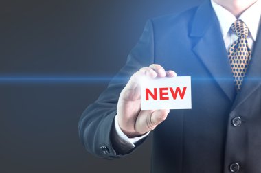 A Businessman holding a white sign with the message new