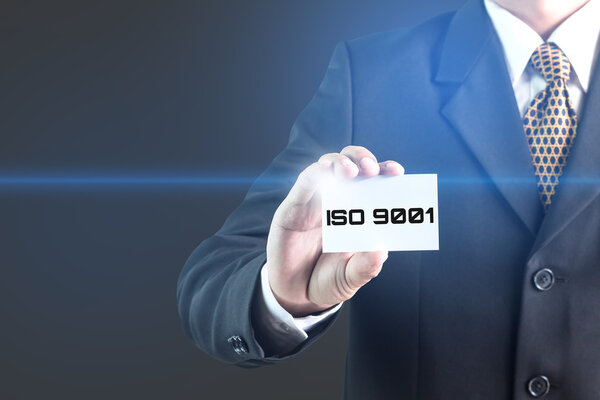 Бизнесмен в дата-центре выбирает этикетку с ISO 9001
