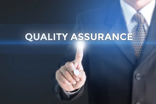 A Businessman holding a white sign with the message quality assurance