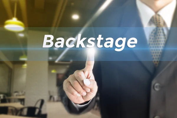 Un Empresario sosteniendo un letrero blanco con el mensaje Backstage . — Foto de Stock