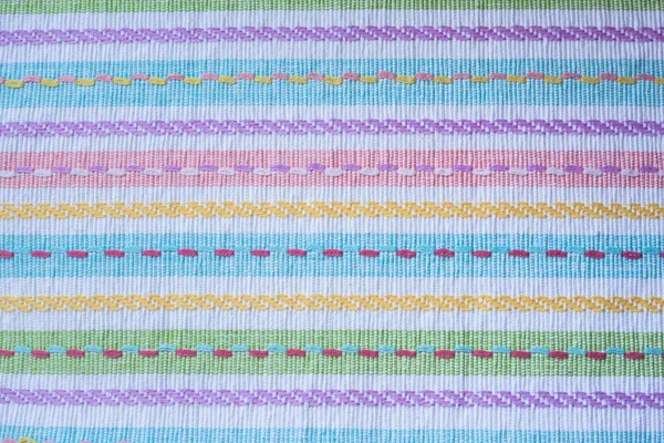 Close-up vista de toalha de mesa de tecido colorido com linha de listra — Fotografia de Stock