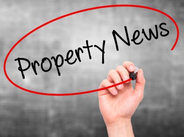 Adam el Emlak Haberleri ile siyah kalemi görsel dağ eteğindeki taş yığını üzerinde yazma.