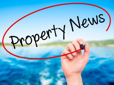 Adam el Emlak Haberleri ile siyah kalemi görsel dağ eteğindeki taş yığını üzerinde yazma.