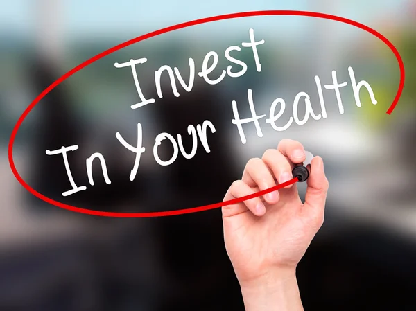 Man Hand writing Invest In Your Health with black marker on visu — Stock Photo, Image