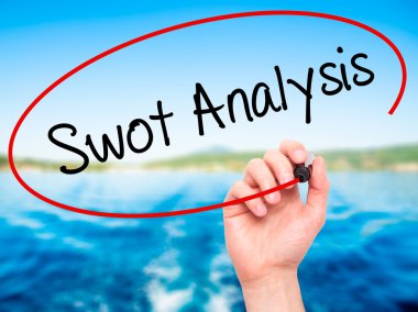 Adam el SWOT analizi ile siyah kalemi görsel dağ eteğindeki taş yığını üzerinde yazma.