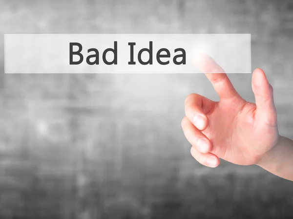 Bad Idea - Ручное нажатие кнопки на размытом фоне концепции — стоковое фото