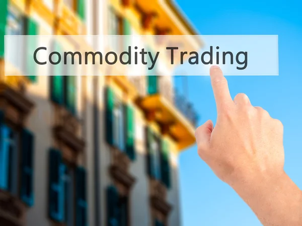 Commodity Trading - Hand pressing a button on blurred background — Stock Photo, Image