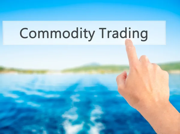 Commodity Trading - Hand pressing a button on blurred background — Stock Photo, Image