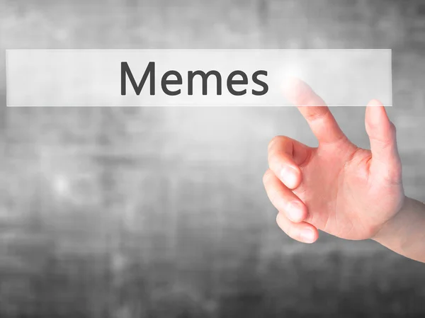 Memes - Hand indrukken van een knop op onscherpe achtergrond concept op — Stockfoto