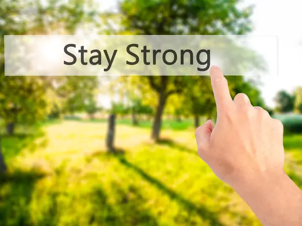 Stay Strong - Hand pressing a button on blurred background — Stock Photo, Image