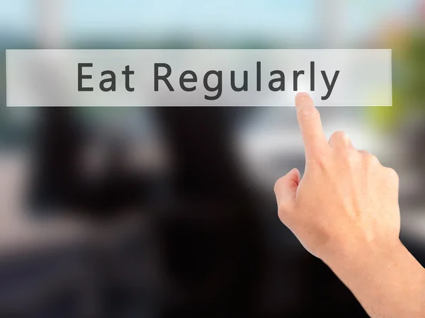 Eat Regularly - Hand pressing a button on blurred background con — Stock Photo, Image